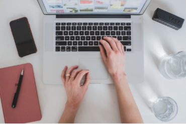 Homem sorrindo e apresentando um curso online de marketing digital em uma tela de laptop