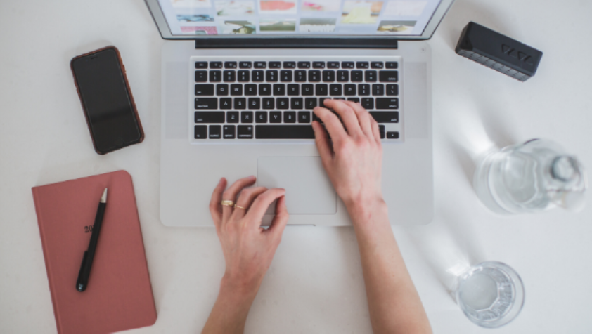 Homem sorrindo e apresentando um curso online de marketing digital em uma tela de laptop