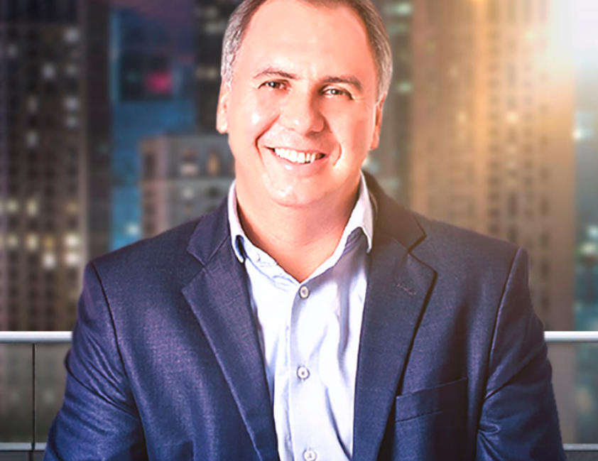Marcos Trombetti em pose de inspiração com símbolos de riqueza ao redor, promovendo o download de Ideias Milionárias.