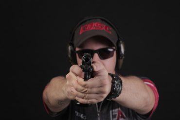 Atirador profissional praticando tiro dinâmico em estande de competição