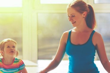 Mulher sorrindo e praticando exercícios de mamãe fitness com bebê