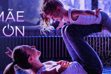 Mulher sorrindo treinando em casa com o curso "A Mãe Tá ON" do BTFIT em tela, demonstrando empenho e resultados.